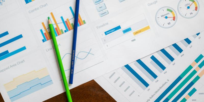 Data charts and writing materials on a surface